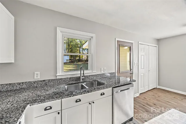 a kitchen with granite countertop a sink and a window