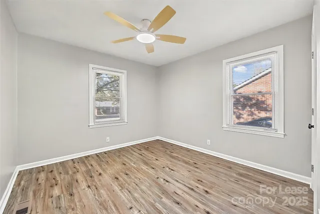 a view of empty room with wooden floor
