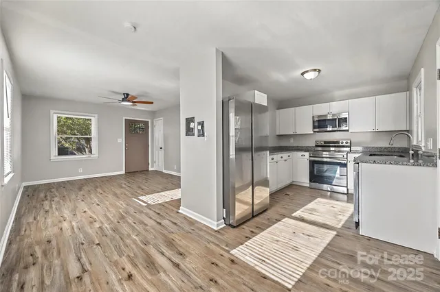 a kitchen with granite countertop a refrigerator and a stove top oven