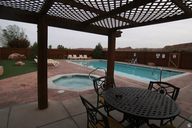 3853 South Red Valley Circle, Unit 22A1 Moab, UT 84532 - Photo 26 of 28 Community pool with a fenced backyard, a patio, a pergola, a community hot tub, and outdoor dining space