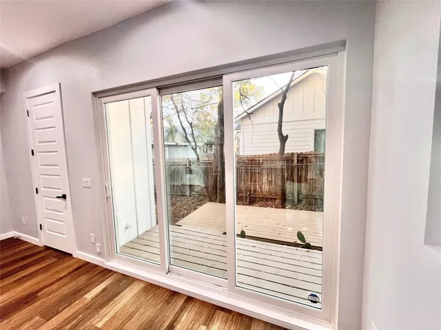 a view of a bedroom with wooden floor and windows