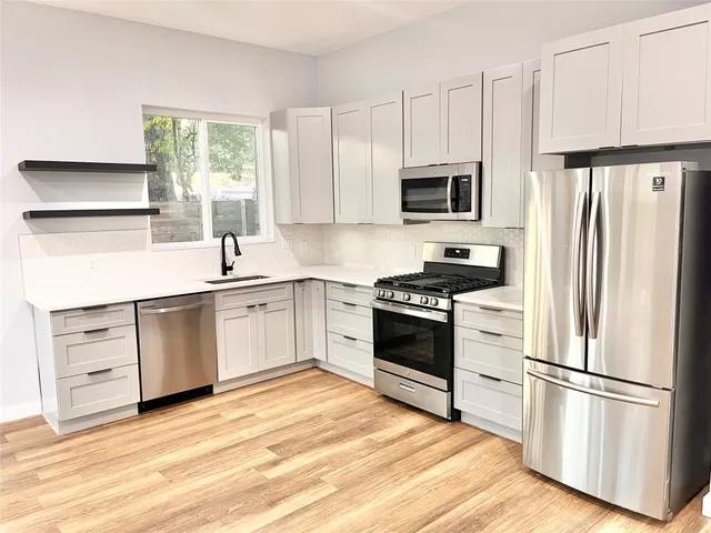 a kitchen with white cabinets and stainless steel appliances