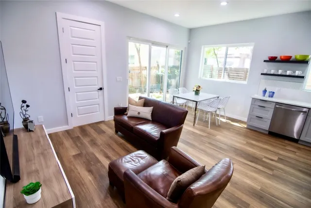 a living room with furniture and a wooden floor