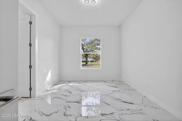 a view of a hallway with kitchen and stainless steel appliances
