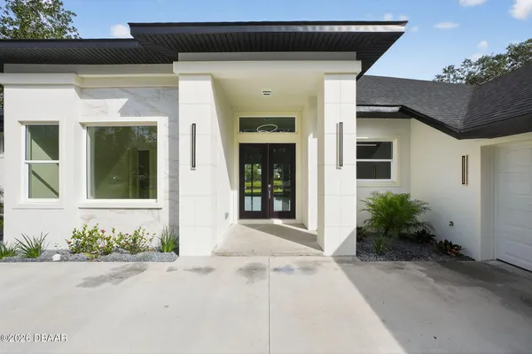 a front view of a house with a garden