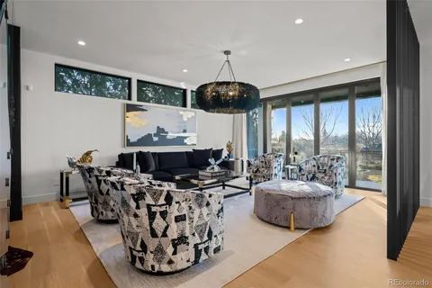 a living room with furniture a chandelier and a large window
