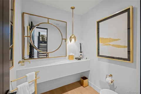 a view of an empty room with wooden floor and stairs