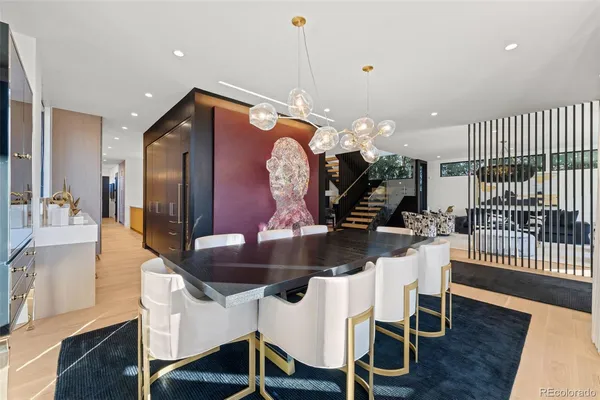 a kitchen with stainless steel appliances kitchen island granite countertop a table chairs and a wooden floor
