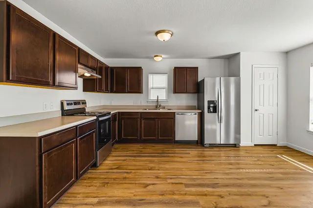 a kitchen with stainless steel appliances granite countertop a refrigerator sink and cabinets