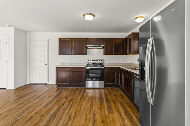 a kitchen with a refrigerator and a stove top oven