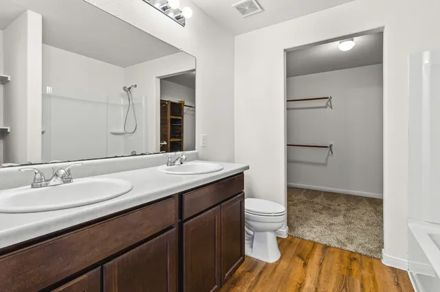 a bathroom with a sink a toilet and shower
