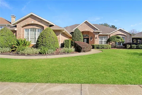 a front view of a house with a garden and yard