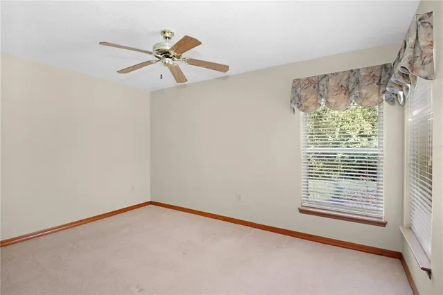 a view of a livingroom with a ceiling fan and window