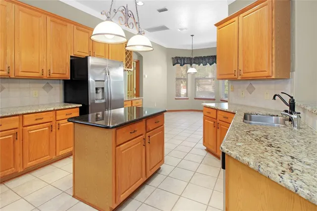 a kitchen with granite countertop a sink a window and a counter top space