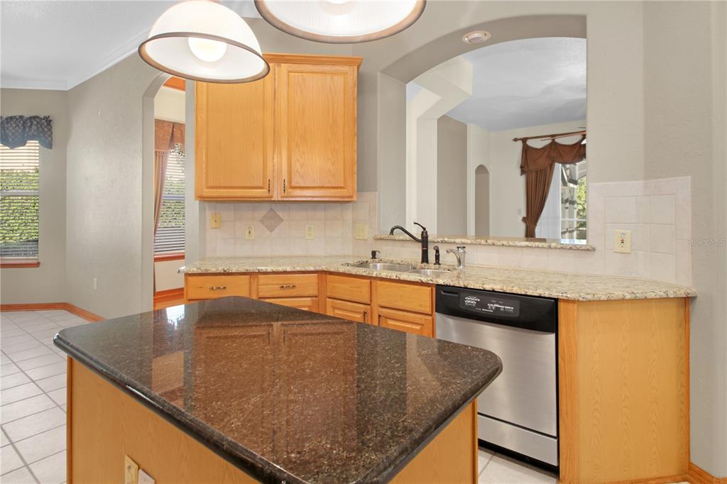 400 Interlachen Court DeBary, FL 32713 - Photo 7 of 42 a kitchen with granite countertop a sink a window and a counter top space