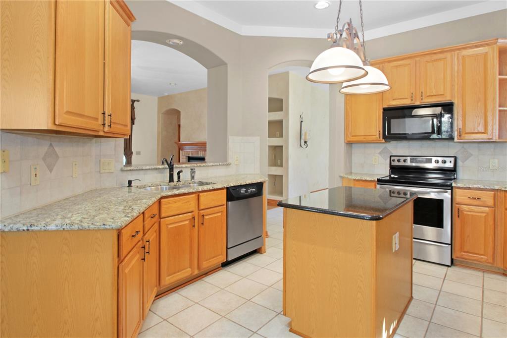 400 Interlachen Court DeBary, FL 32713 - Photo 8 of 42 a kitchen with stainless steel appliances granite countertop a sink a stove and a refrigerator