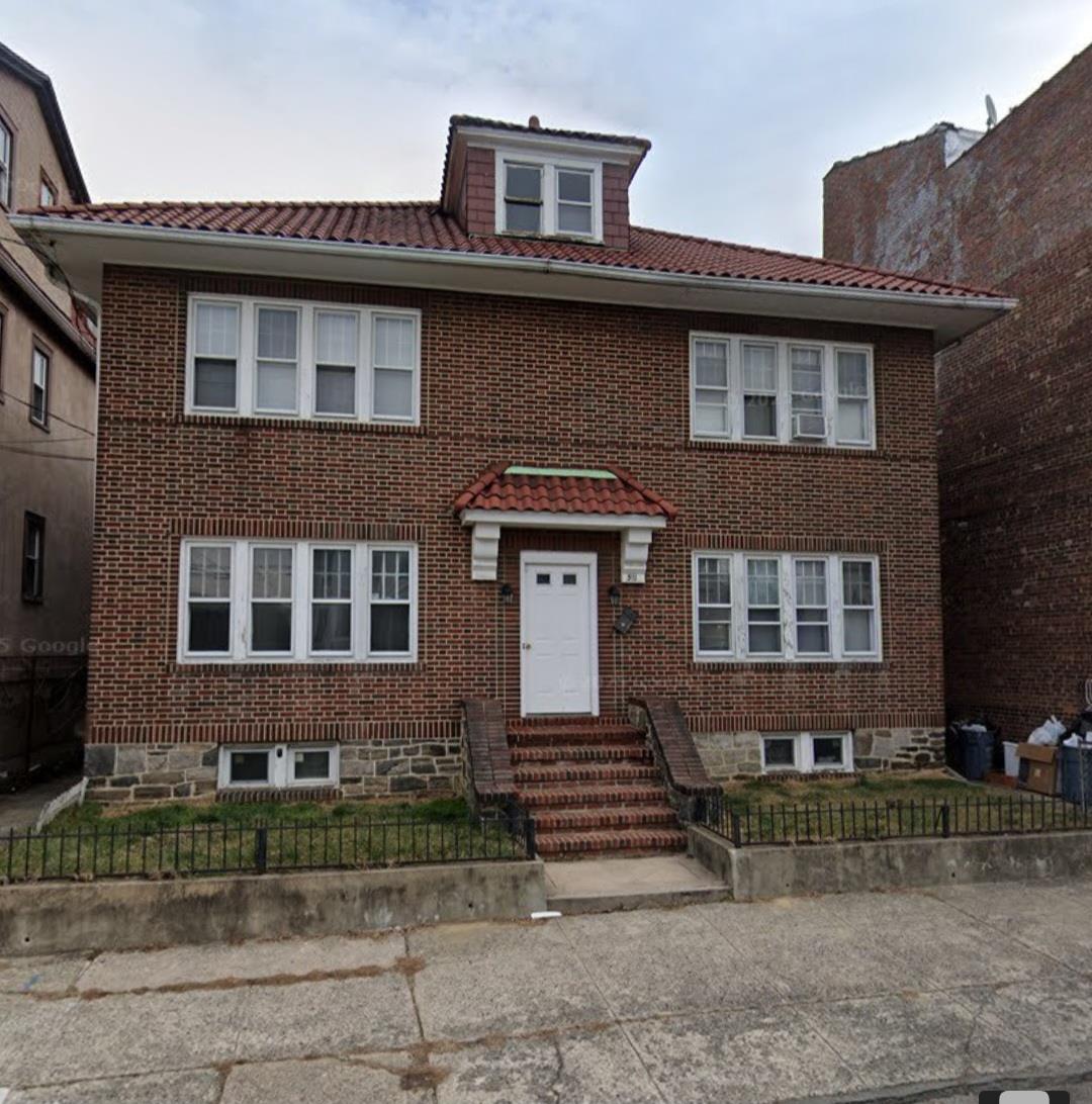 511 South 11th Avenue Mount Vernon, NY 10550 - Photo 1 of 1 View of front of property with brick siding, a fenced front yard, entry steps, and a tiled roof