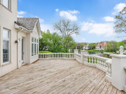 a view of a balcony with wooden floor and fence