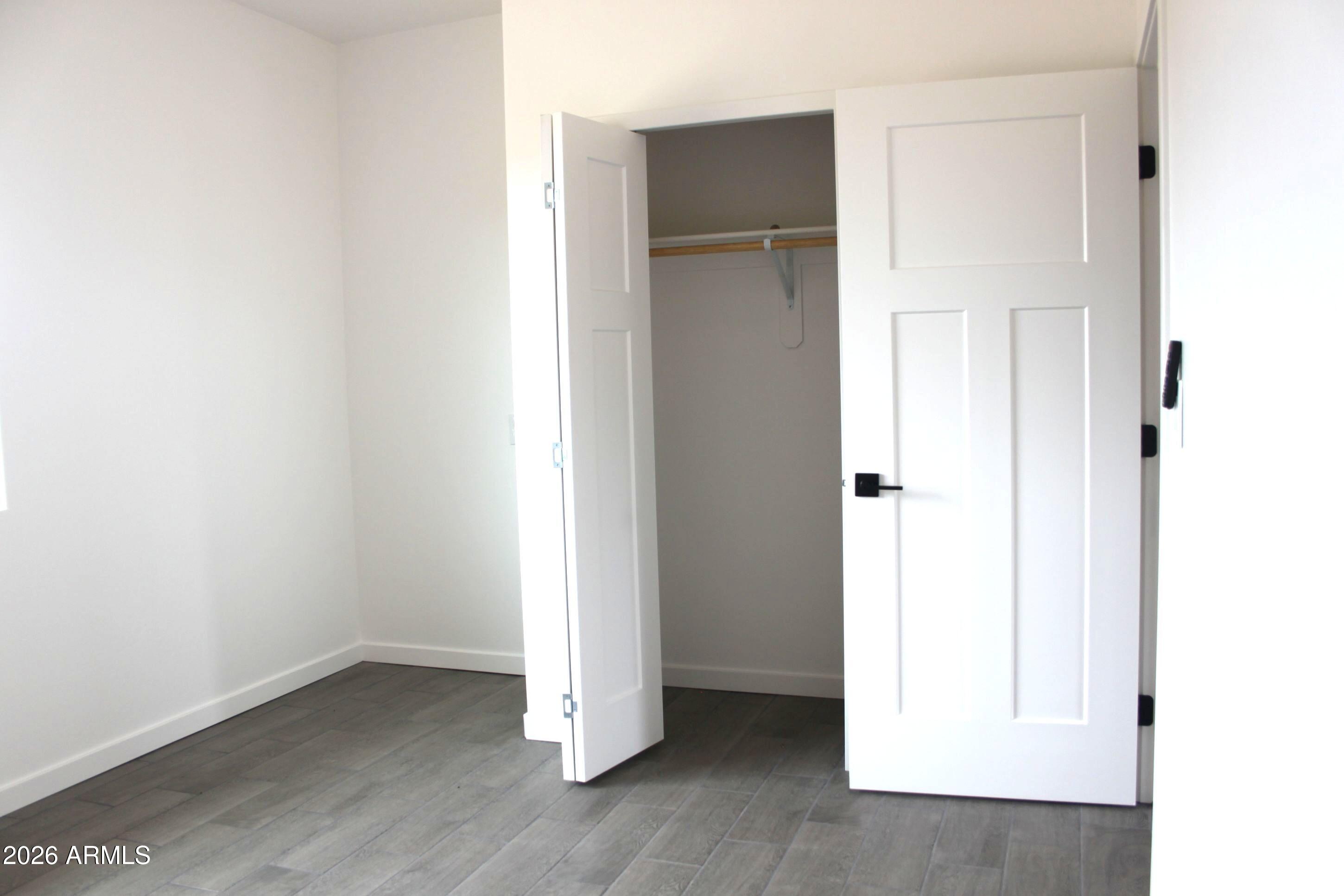 6370 South Jaxel Road Hereford, AZ 85615 - Photo 20 of 58 a view of an empty room with wooden floor and closet