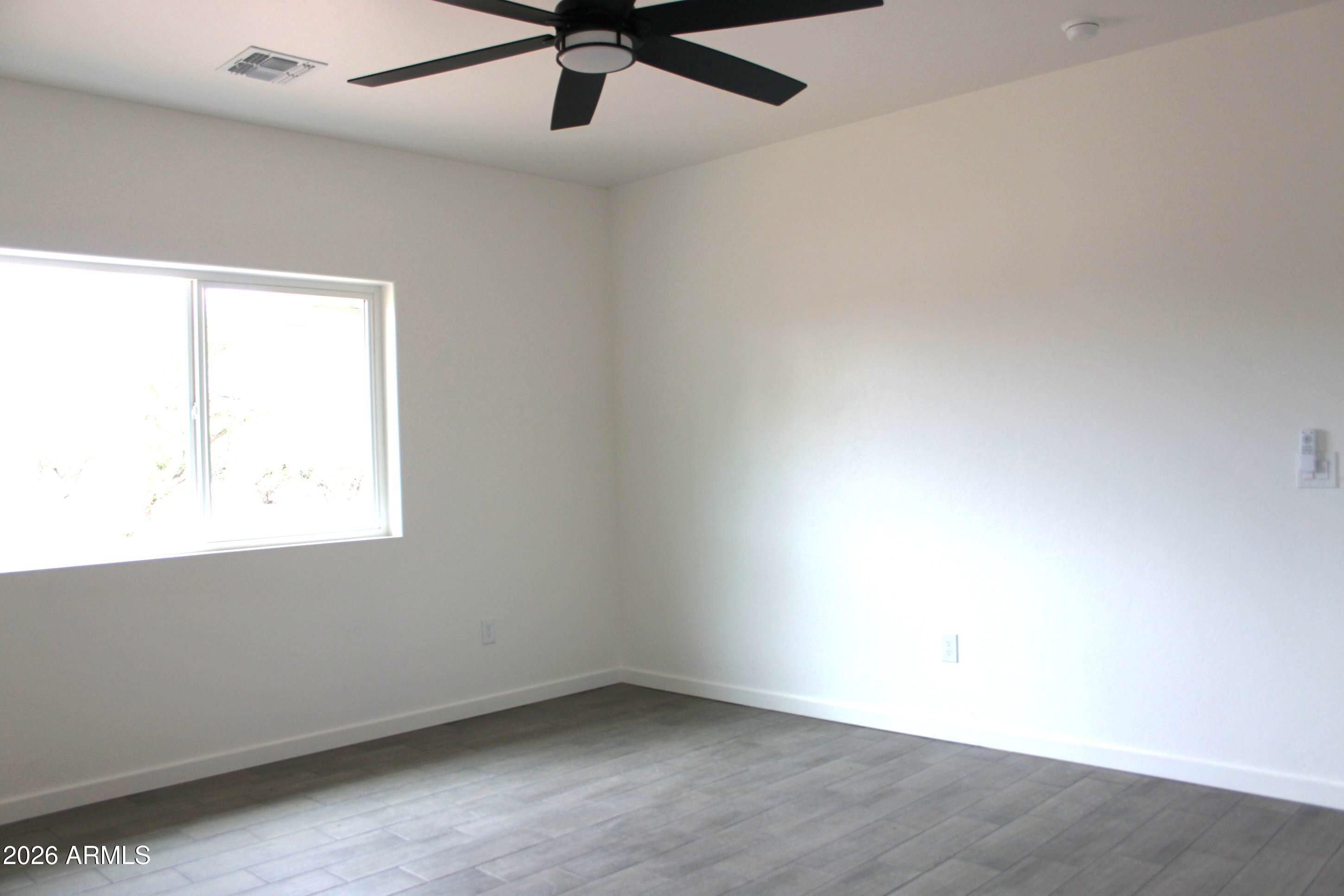 6370 South Jaxel Road Hereford, AZ 85615 - Photo 29 of 58 an empty room with a window and a ceiling fan