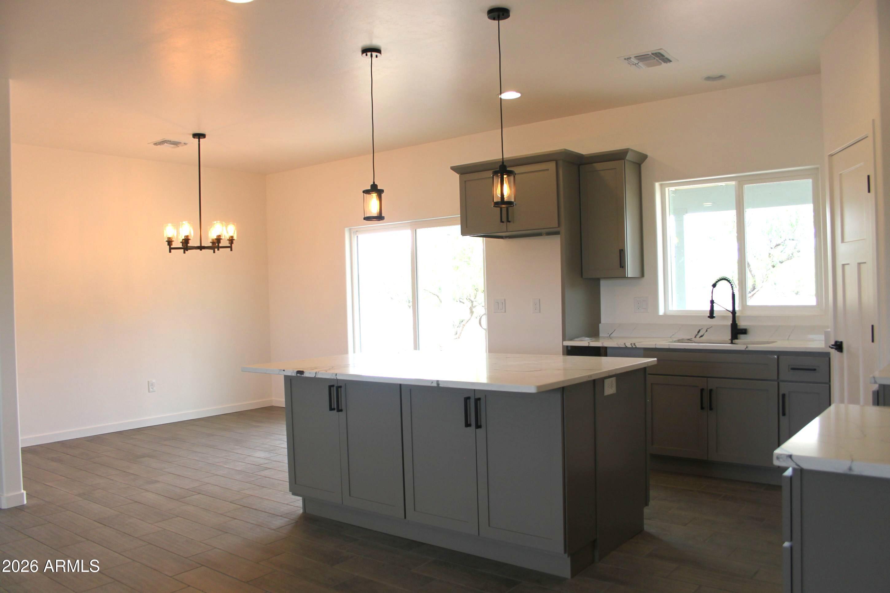 6370 South Jaxel Road Hereford, AZ 85615 - Photo 5 of 58 a kitchen with stainless steel appliances granite countertop a sink a window and chairs
