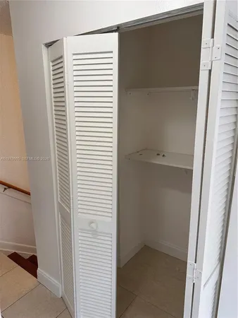 an empty room with a ceiling fan and glass door