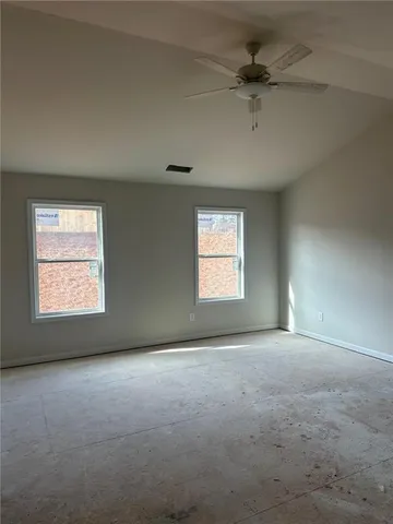 an empty room with a window and a ceiling fan