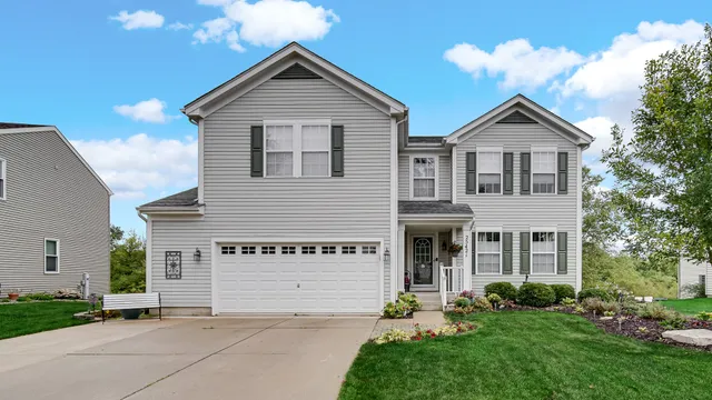 a view of a house with brick walls and a yard with plants