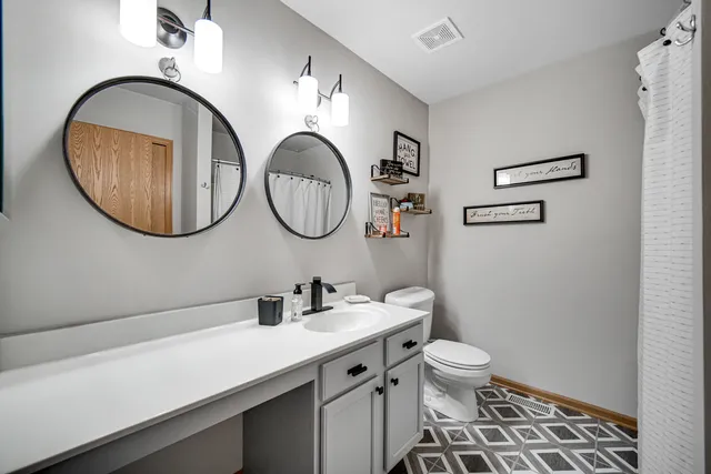 a bathroom with a toilet a sink and a mirror