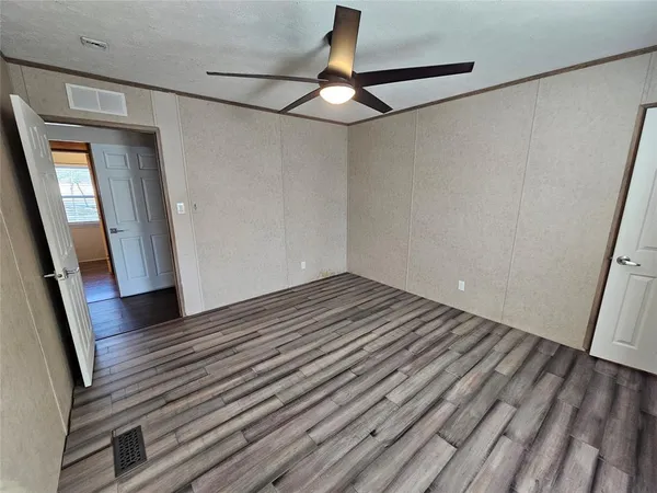 a view of a room with wooden floor and fan