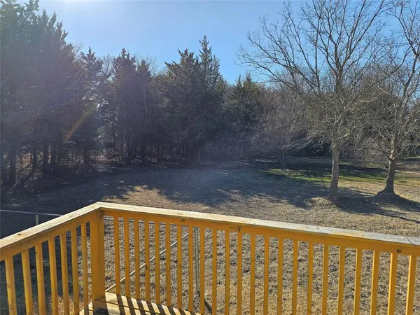 a view of a yard with trees in the background