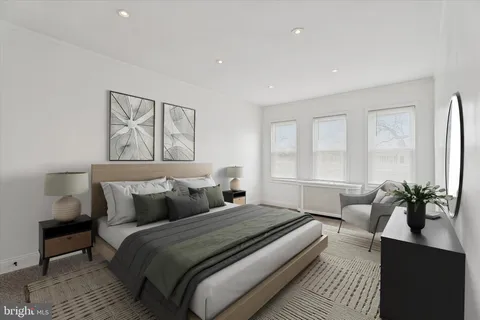 a bedroom with a large bed and windows