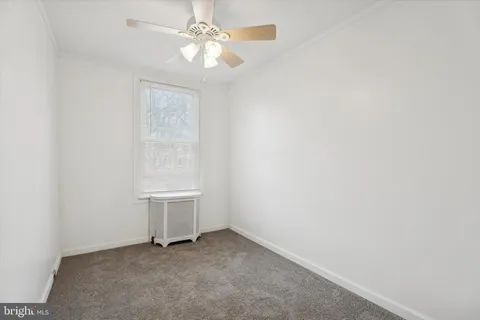 an empty room with a ceiling fan and a window