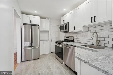 a kitchen with stainless steel appliances granite countertop a refrigerator stove and sink