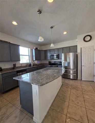 a kitchen with stainless steel appliances granite countertop a sink counter space cabinets and a large window