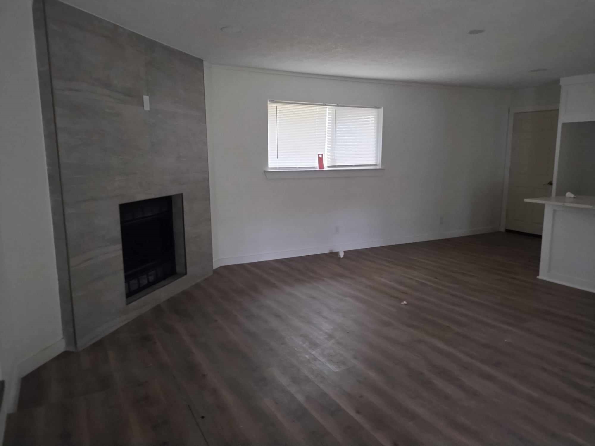 510 West Decatur Avenue Orange, TX 77630 - Photo 8 of 22 an empty room with wooden floor fireplace and windows
