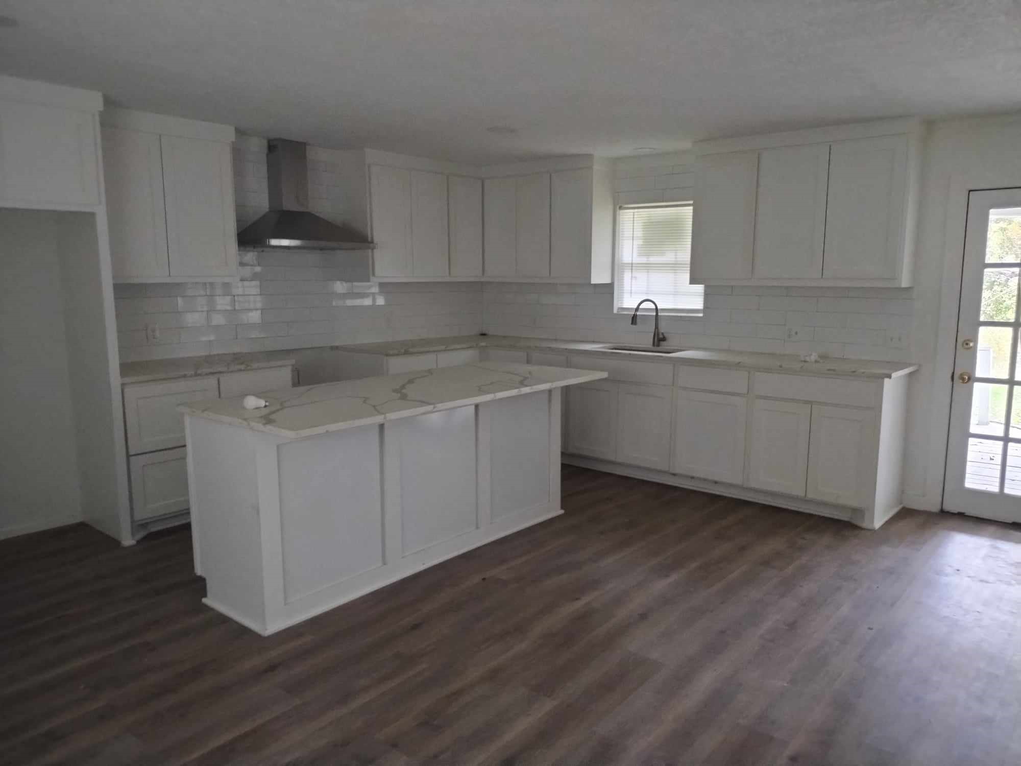 510 West Decatur Avenue Orange, TX 77630 - Photo 10 of 22 a kitchen with a sink cabinets wooden floor and a window