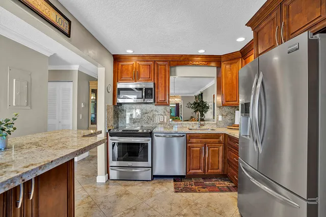 a kitchen with stainless steel appliances granite countertop a refrigerator and a sink