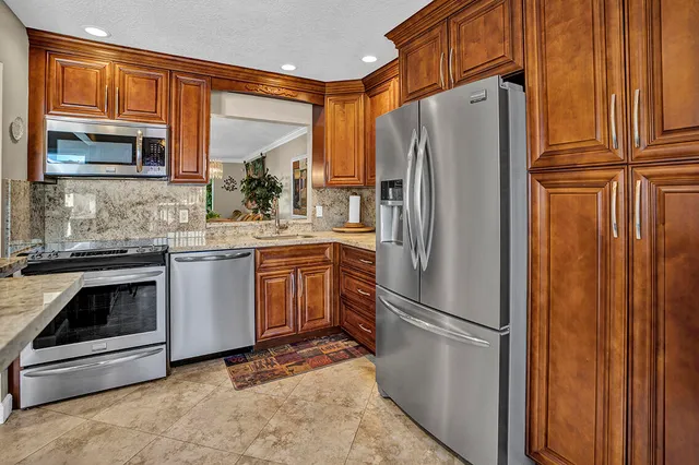 a kitchen with stainless steel appliances a refrigerator sink and cabinets