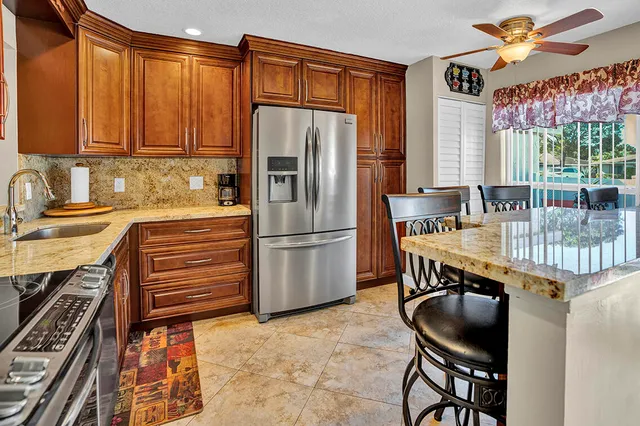 a kitchen with stainless steel appliances a table chairs and a refrigerator