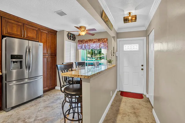 a kitchen with stainless steel appliances granite countertop a refrigerator and a sink