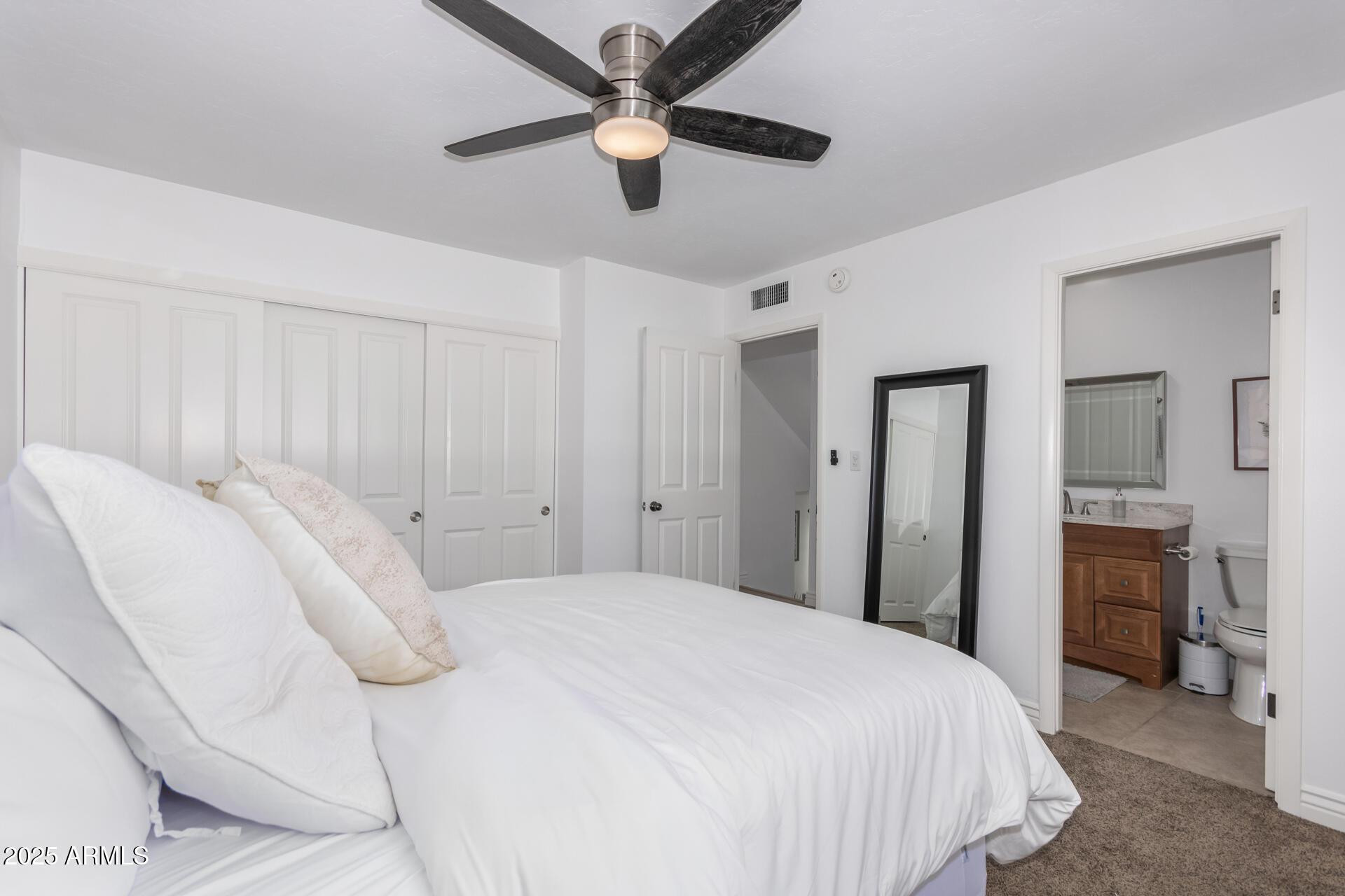 8490 East Chaparral Road Scottsdale, AZ 85250 - Photo 20 of 27 a bedroom with a bed and a chandelier