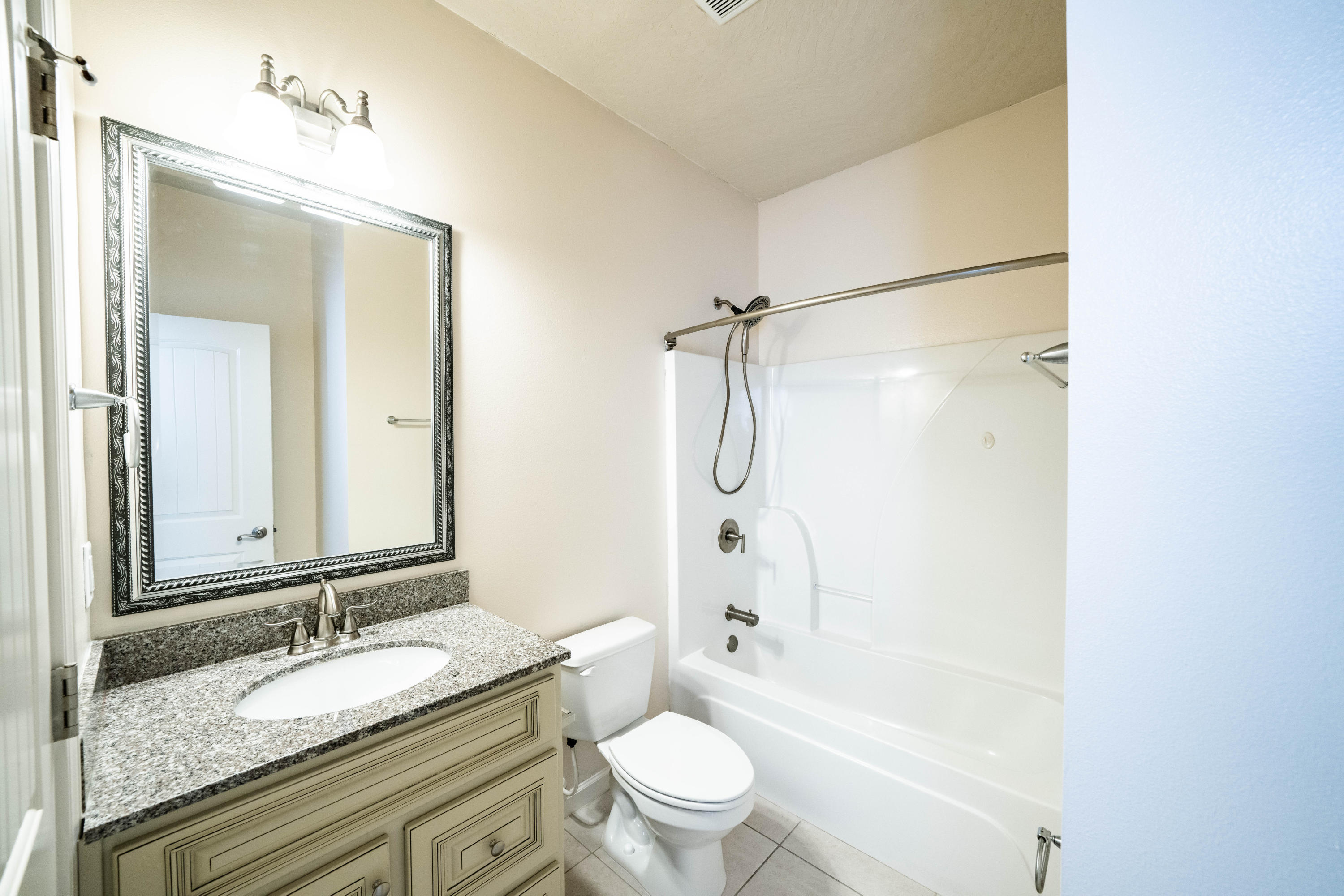 4582 Hermosa Road Crestview, FL 32539 - Photo 13 of 26 a bathroom with a granite countertop sink toilet mirror and shower