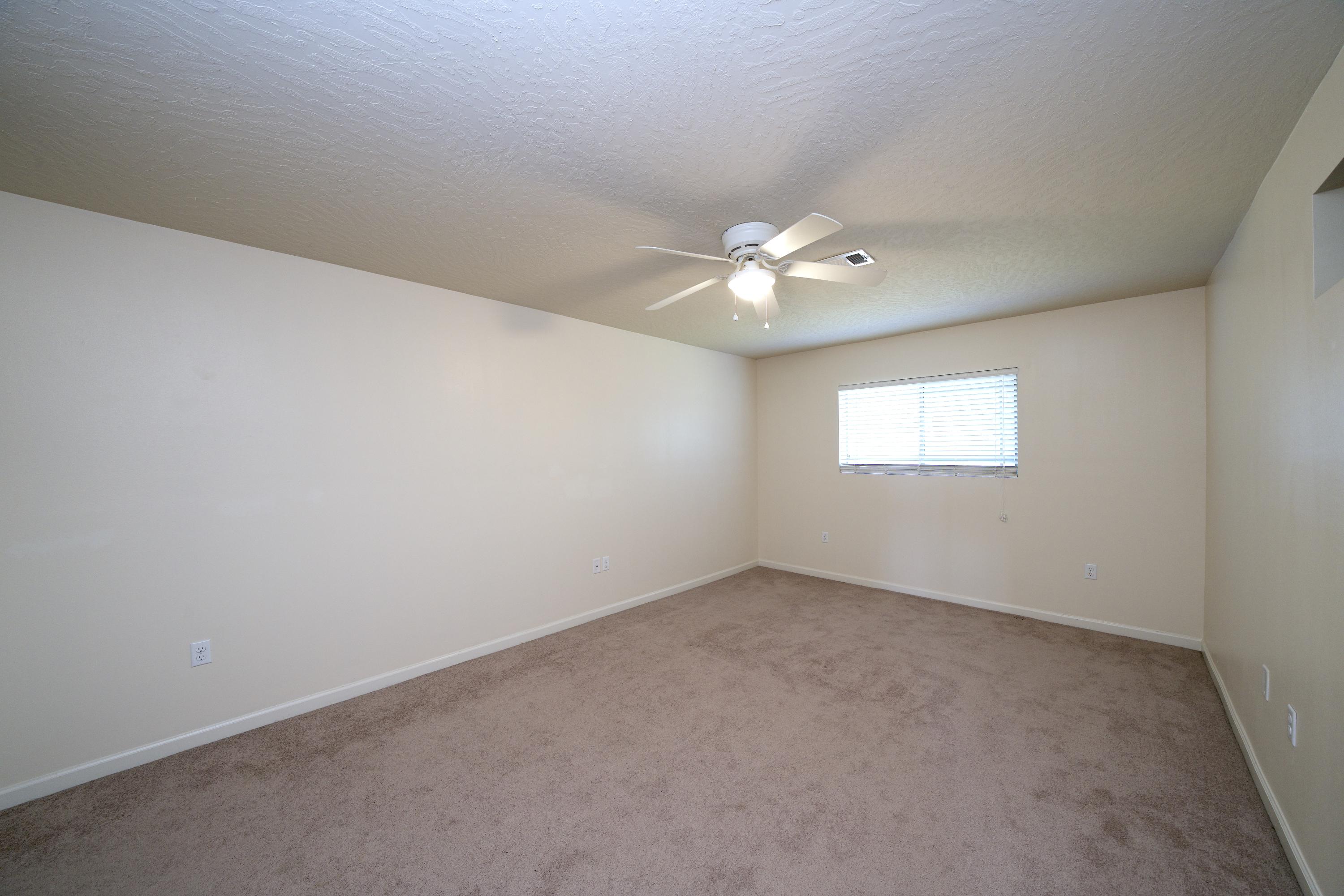 4582 Hermosa Road Crestview, FL 32539 - Photo 19 of 26 an empty room with a chandelier fan and windows