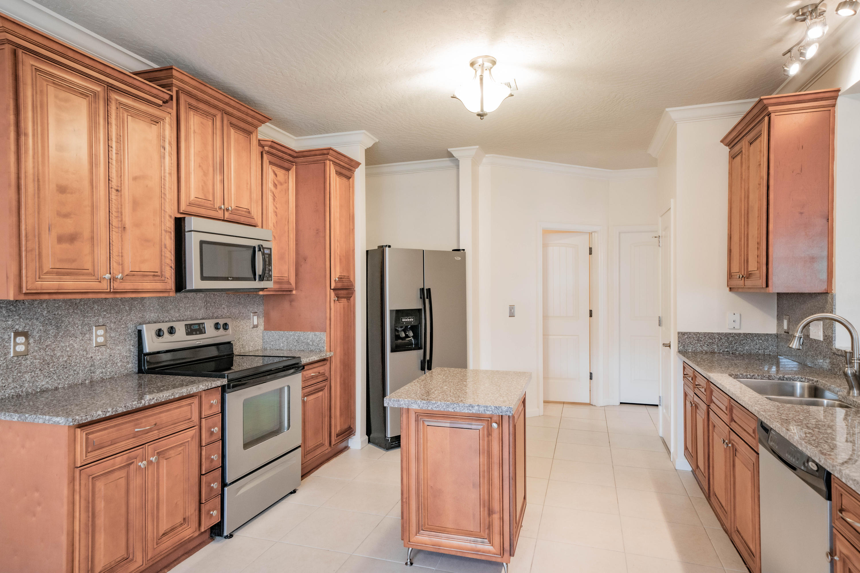 4582 Hermosa Road Crestview, FL 32539 - Photo 6 of 26 a kitchen with stainless steel appliances granite countertop a stove a sink and a refrigerator