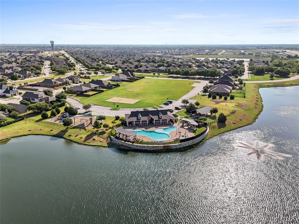 2920 Roper Street Royse City, TX 75189 - Photo 29 of 29 Community lakefront amenity center featuring a swimming pool with integrated spa, a shaded outdoor lounge area, and an adjacent playground