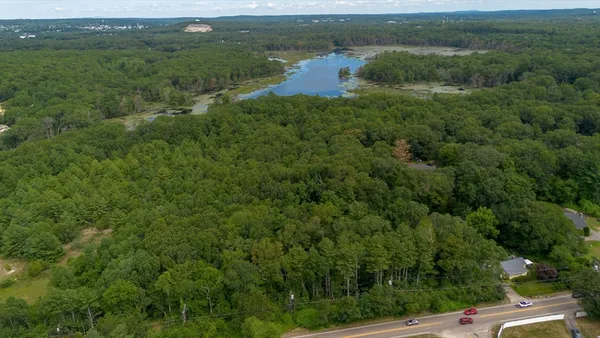 an aerial view of residential houses with outdoor space and trees