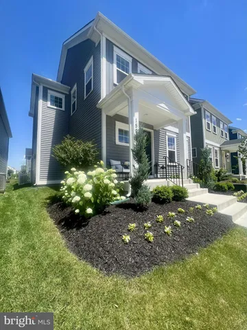 a front view of a house with a yard and potted plants