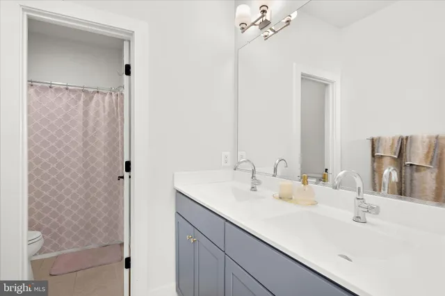 a spacious bathroom with a double vanity sink a mirror and a bathtub