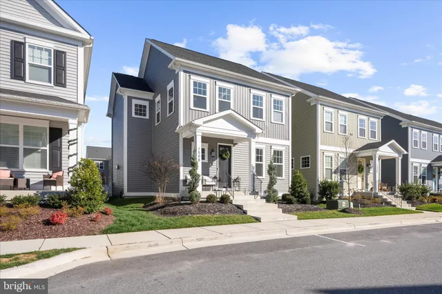a living room with couches and dining table with wooden floor